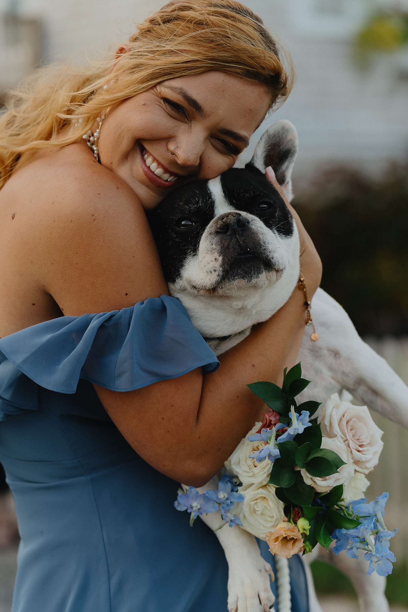 Candid photo of a bride holding a puppy during her wedding day